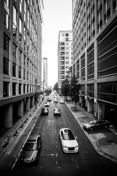 车辆和高层建筑的灰度摄影
